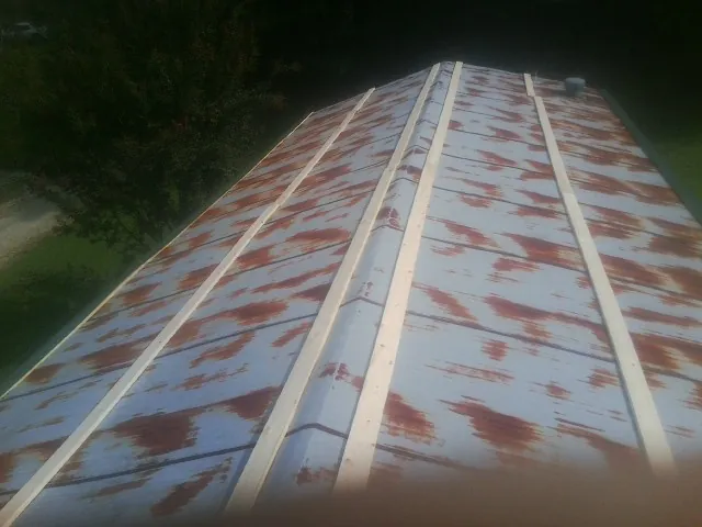 Rusted metal roof panels with new wood purlins before replacement — Storm Damage Roof Repair in Naples by Roofing Brothers