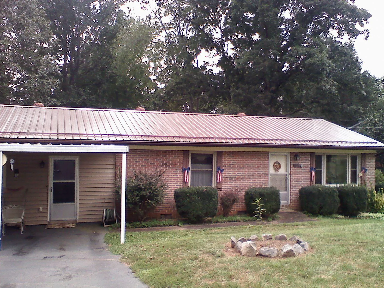 Bronze metal roof and carport on a brick ranch home — Roof Repair work by our crew in Naples